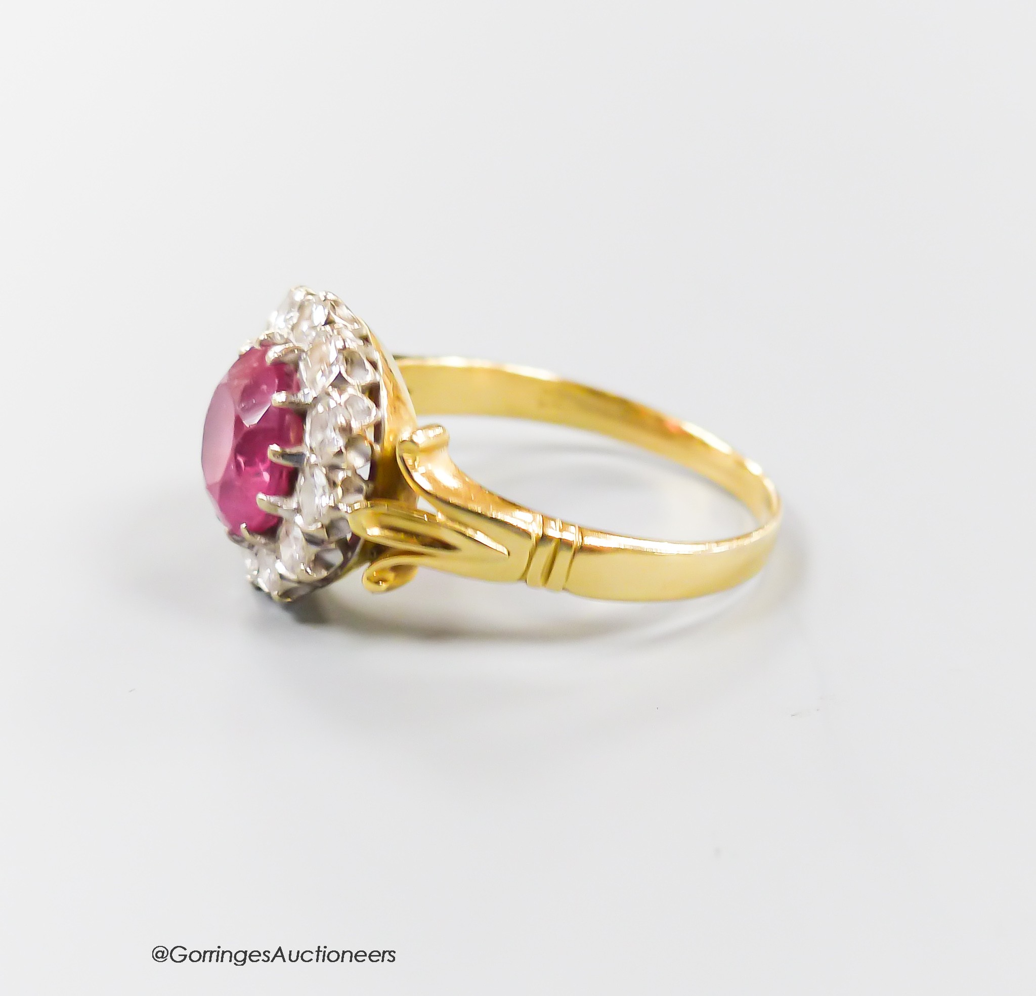 A modern yellow metal, pink tourmaline and diamond set circular cluster ring, size O, gross 5.1 grams.